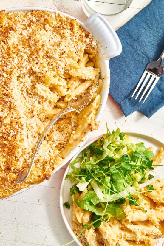 Baked Macaroni and Cheese in a pan and on a plate with salad.