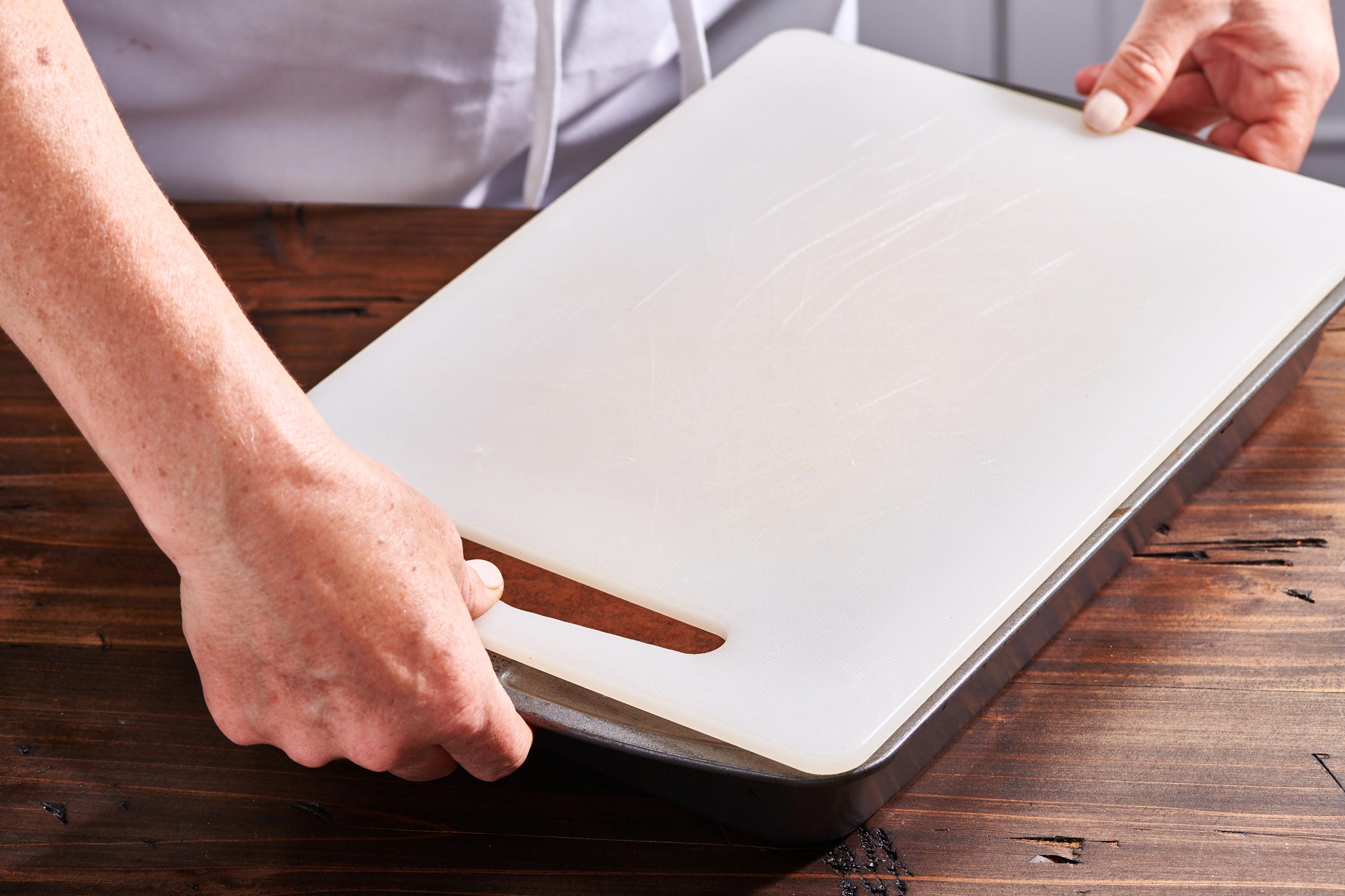 Baking dish covered with a cutting board.