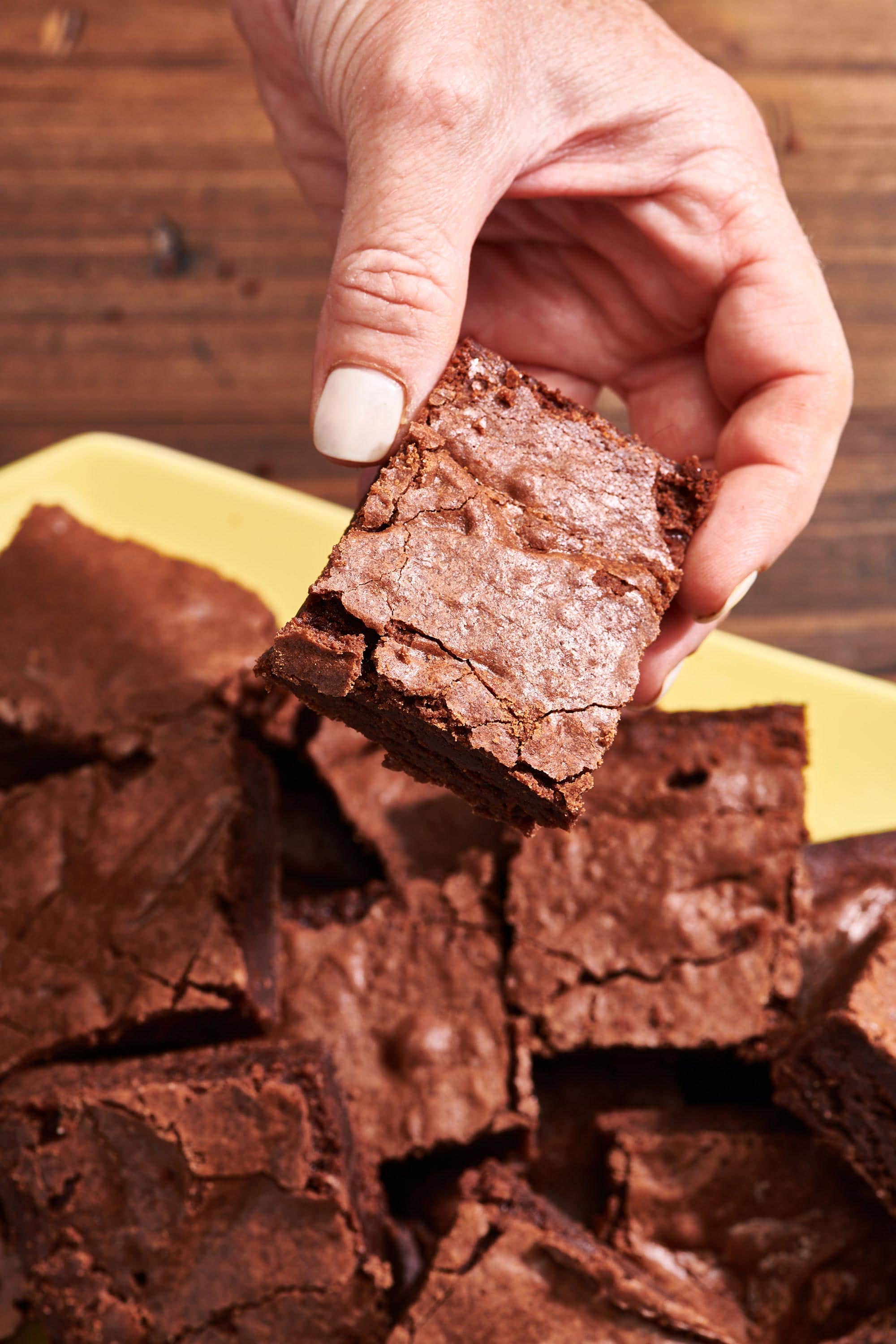 Woman holding a Fudgy Brownie.