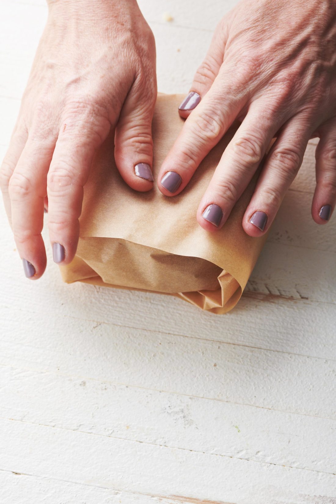 Woman wrapping Gingersnaps in parchment paper.