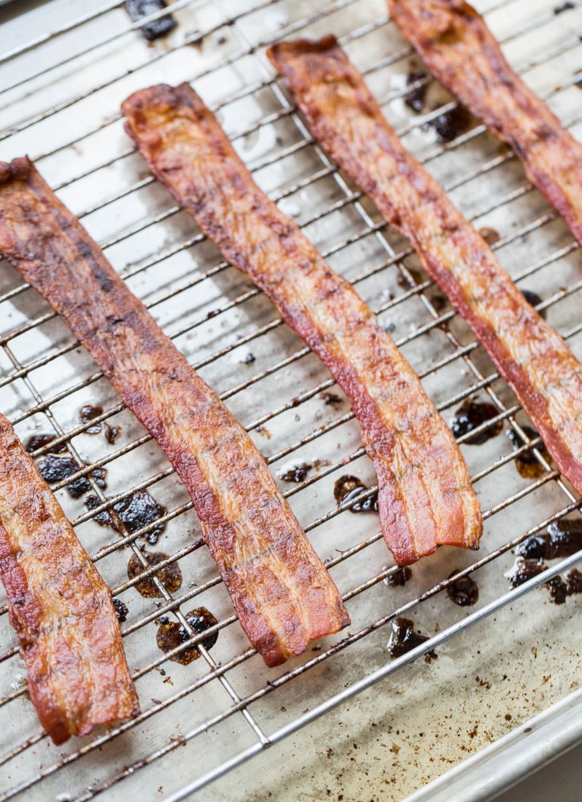 Bacon spread on a wire rack.