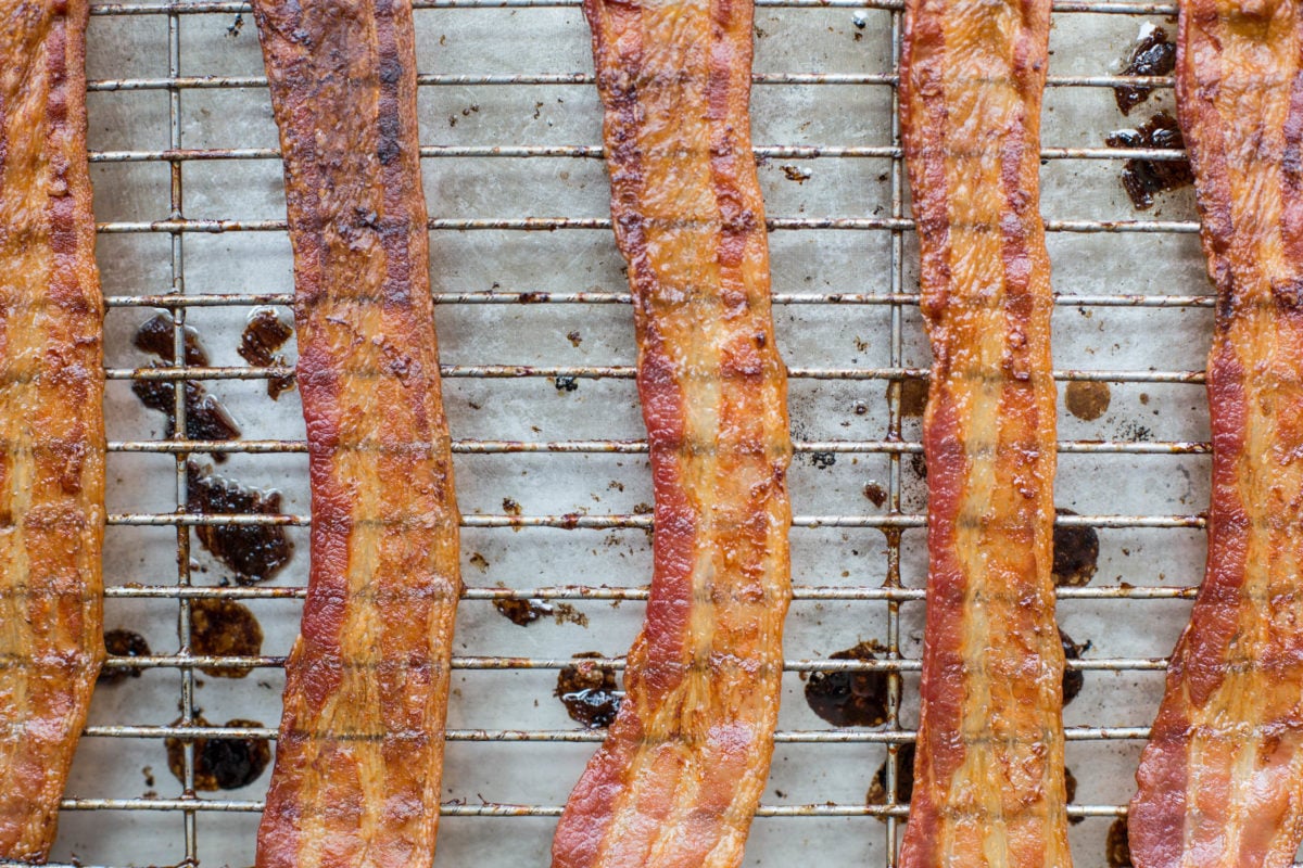 Bacon on a wire rack set on a baking sheet.