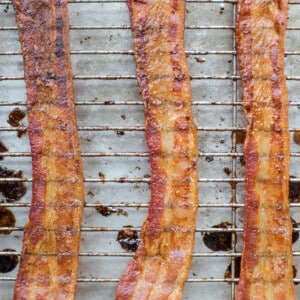 Bacon on a wire rack set on a baking sheet.
