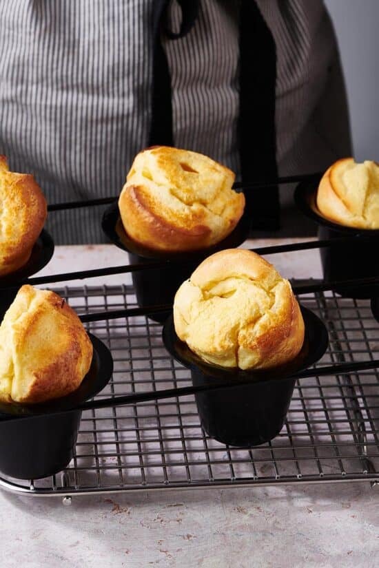 Set of popovers in tins on a wire rack.