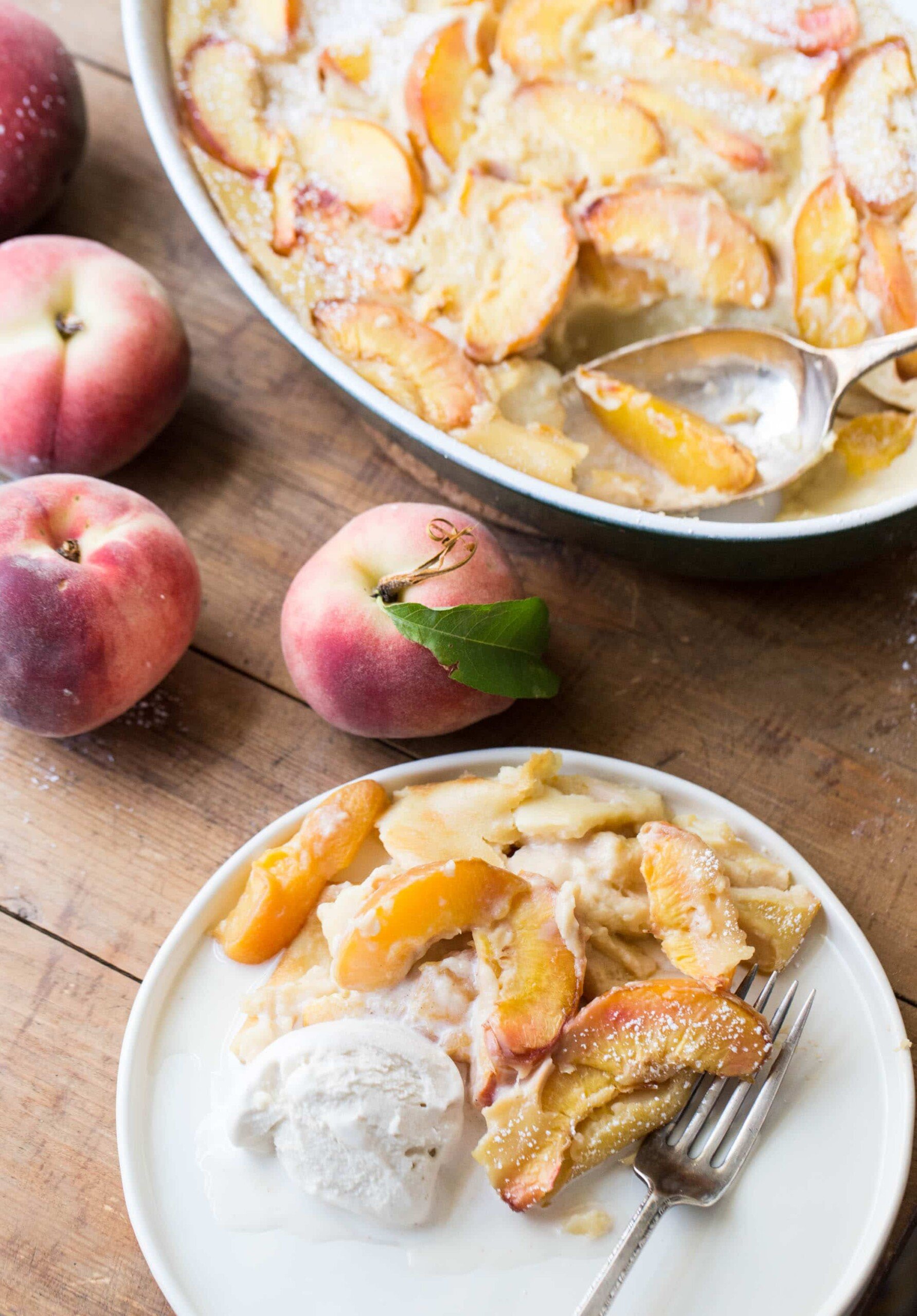 Ice cream and Peach Clafoutis on a plate with a fork.