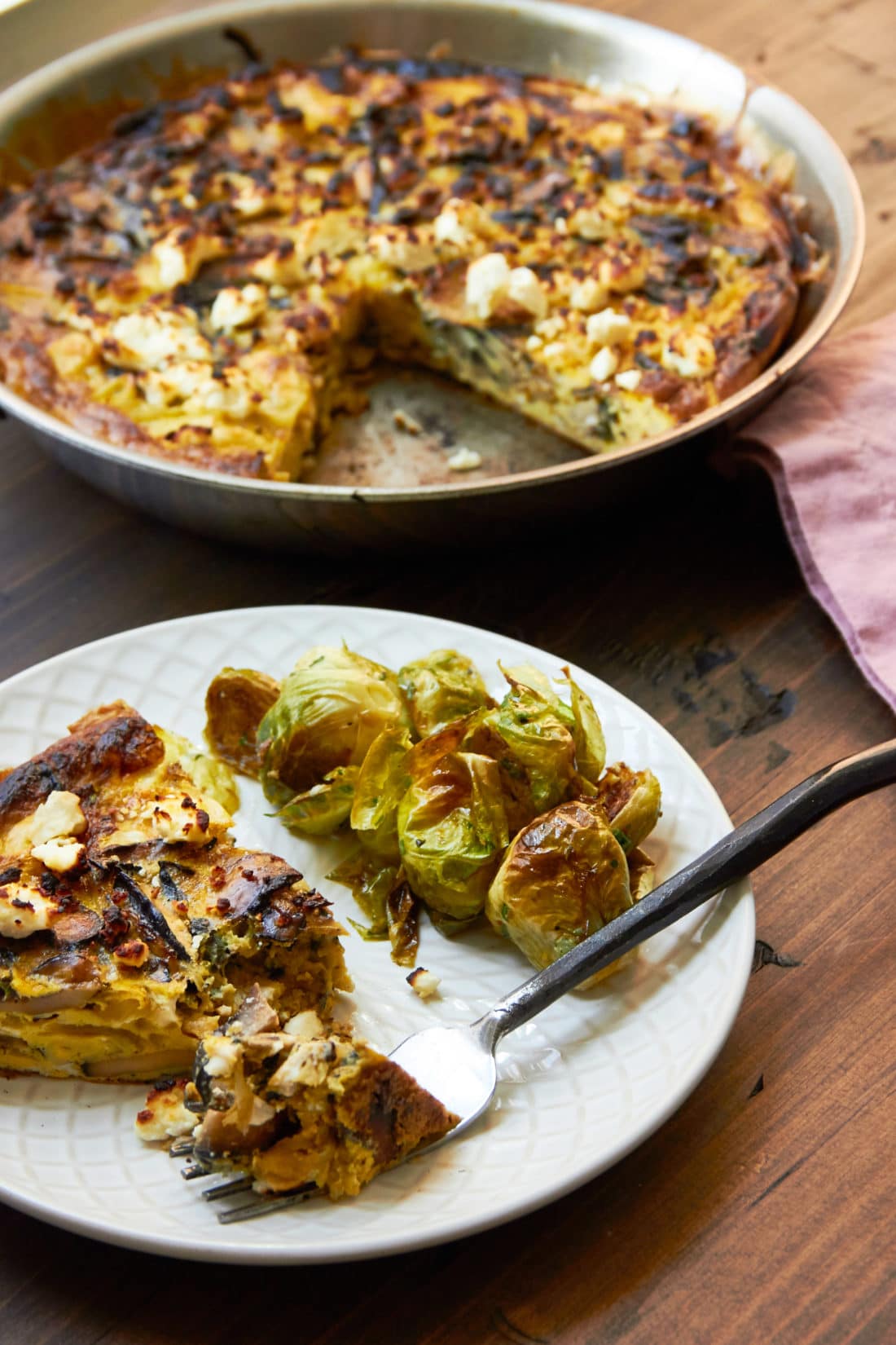 Mushroom, Caramelized Onion and Feta Frittata on a plate with brussels sprouts.