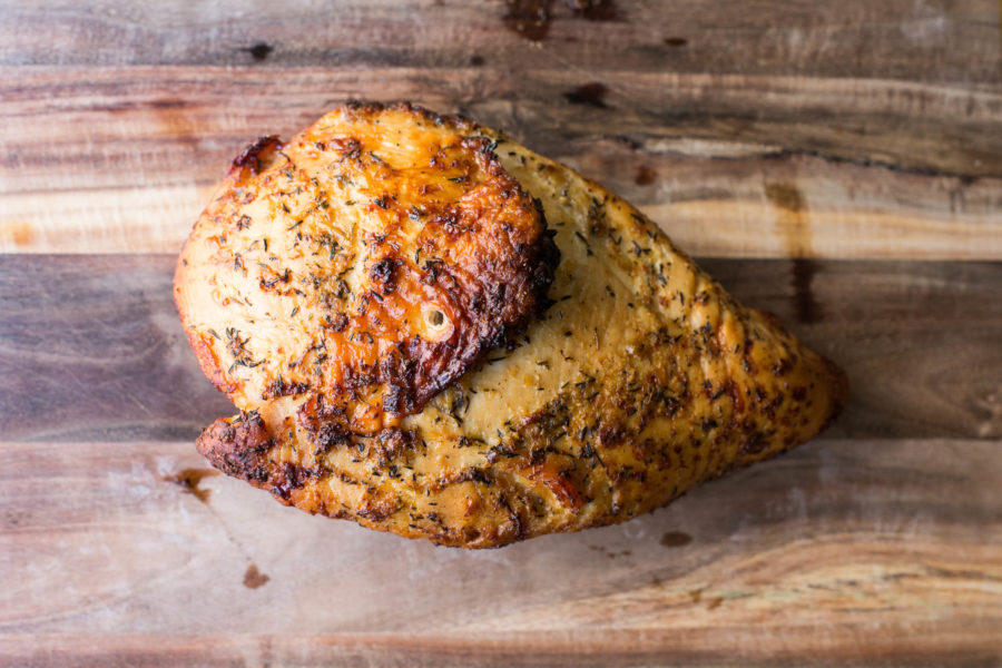 Roasted turkey breast with lemon and garlic on cutting board