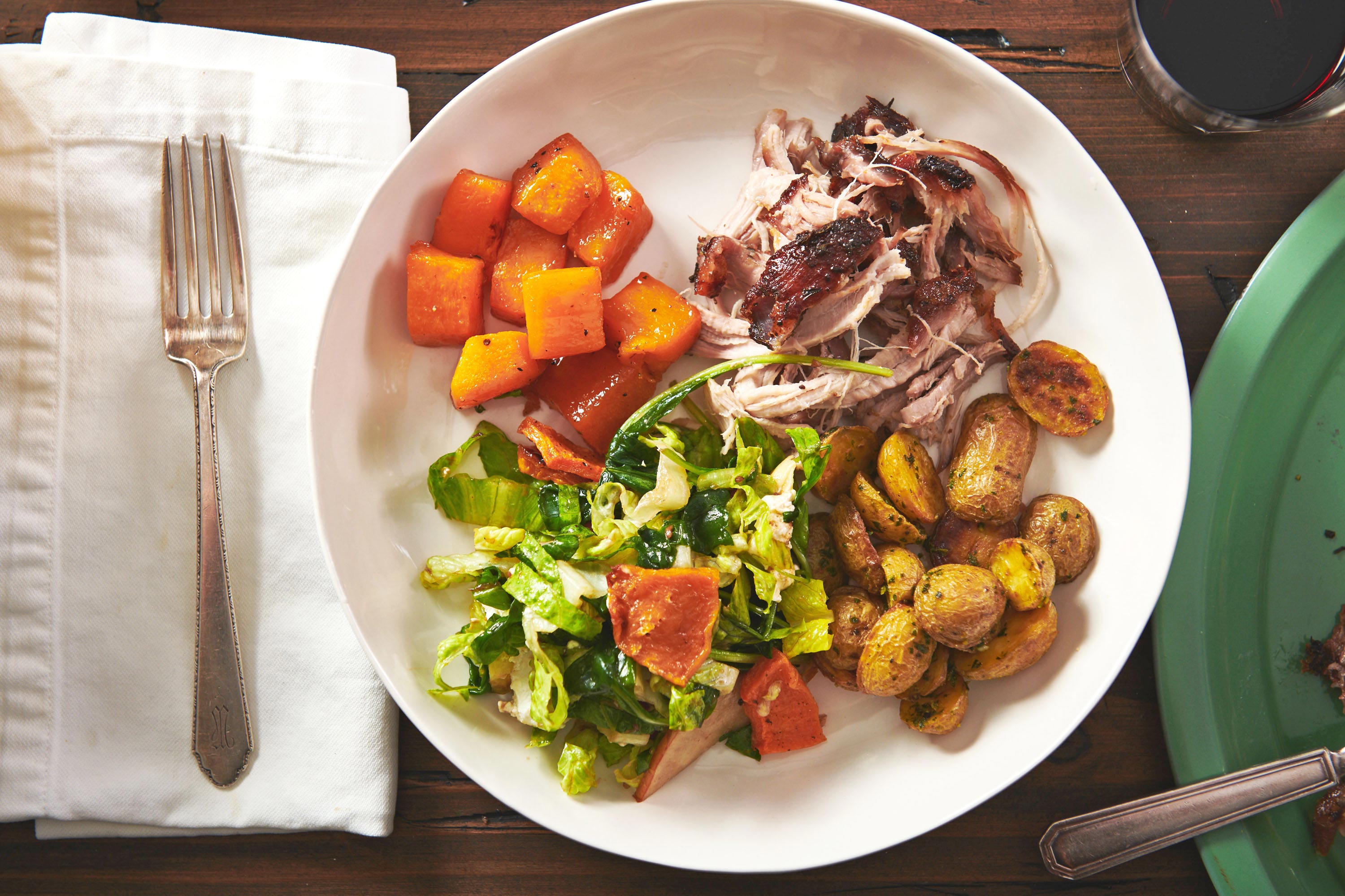 Roasted Butternut Squash on a plate with meat, potatoes, and salad.