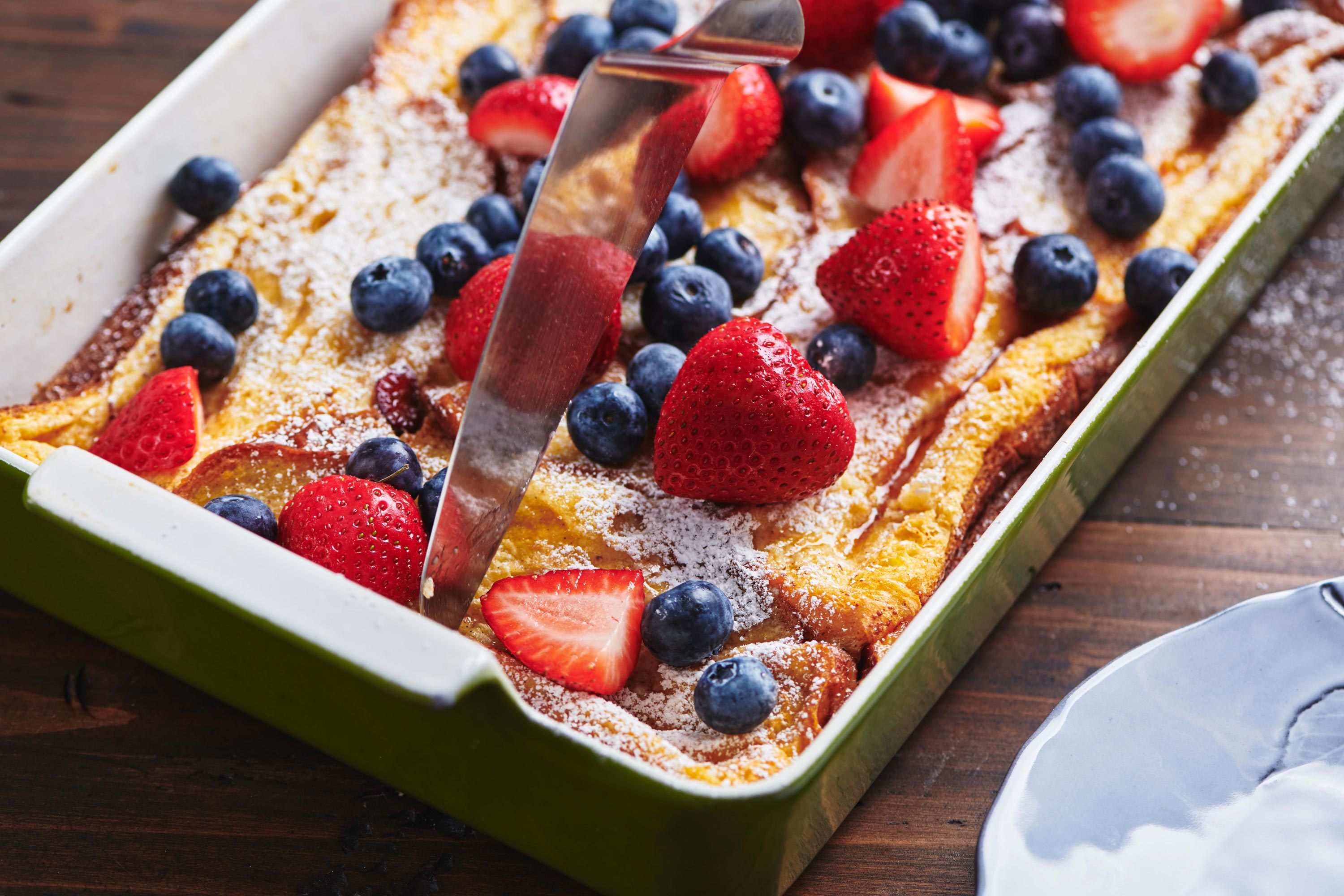 Lazy Oven French Toast in pan with berries on top.