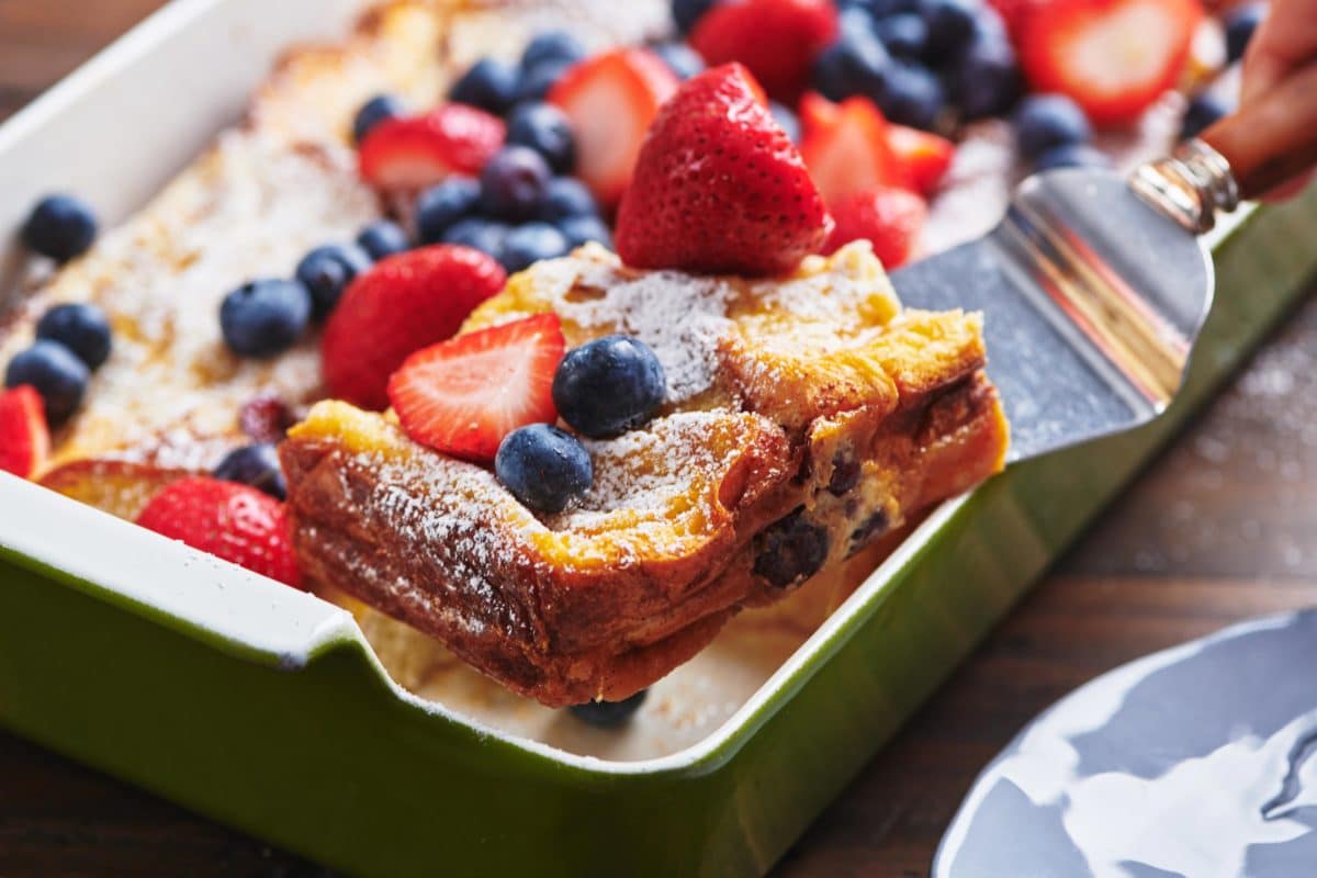 Spatula grabbing French Toast topped with berries.