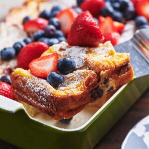 Spatula grabbing French Toast topped with berries.