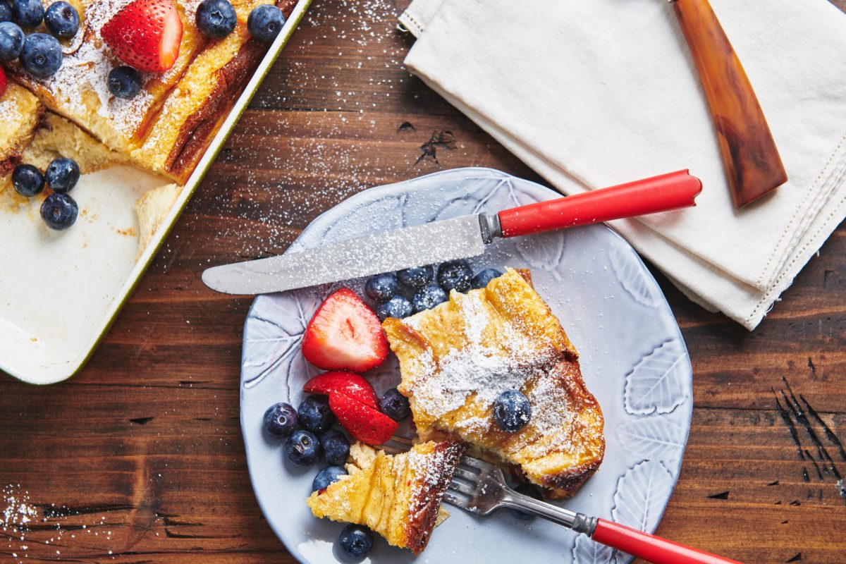 Fork and knife on a plate with French Toast and berries.