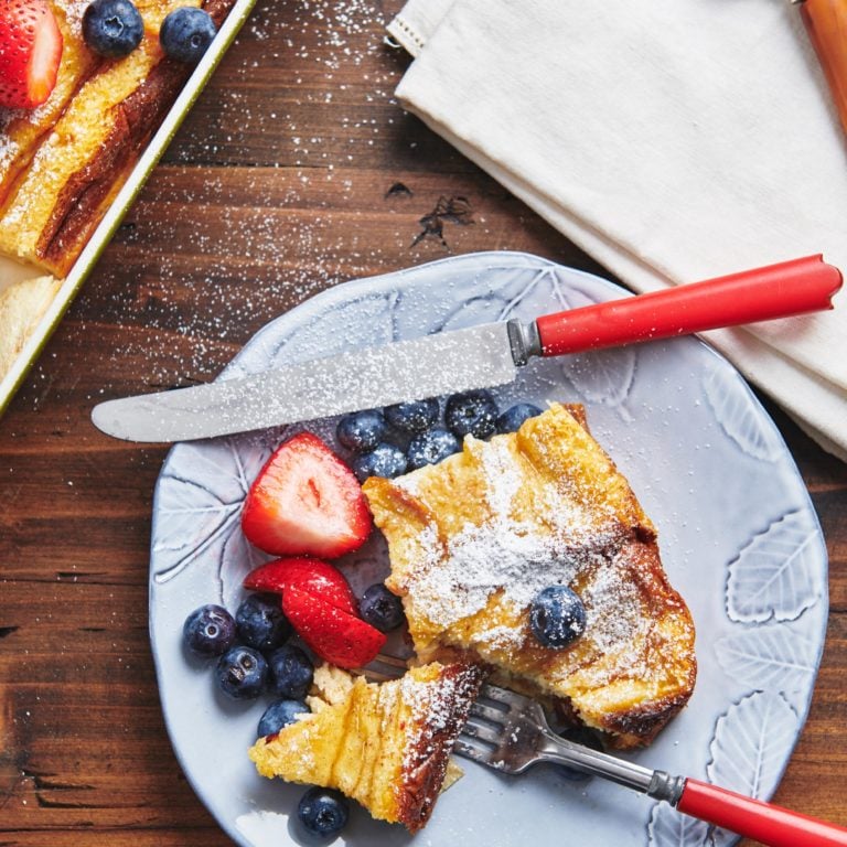 Fork and knife on a plate with French Toast and berries.