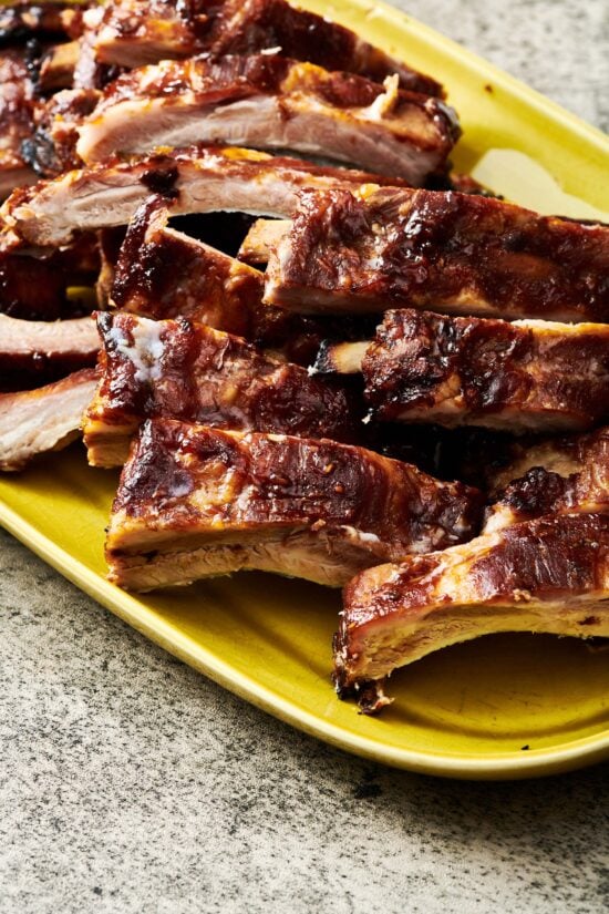 Asian Baby Back Ribs piled on a yellow plate.