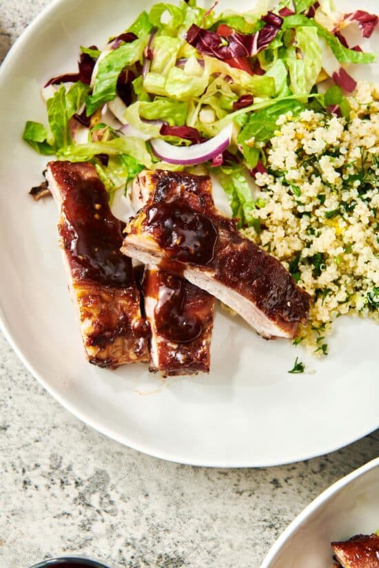 Plate of salad, grains, and Asian Baby Back Ribs.