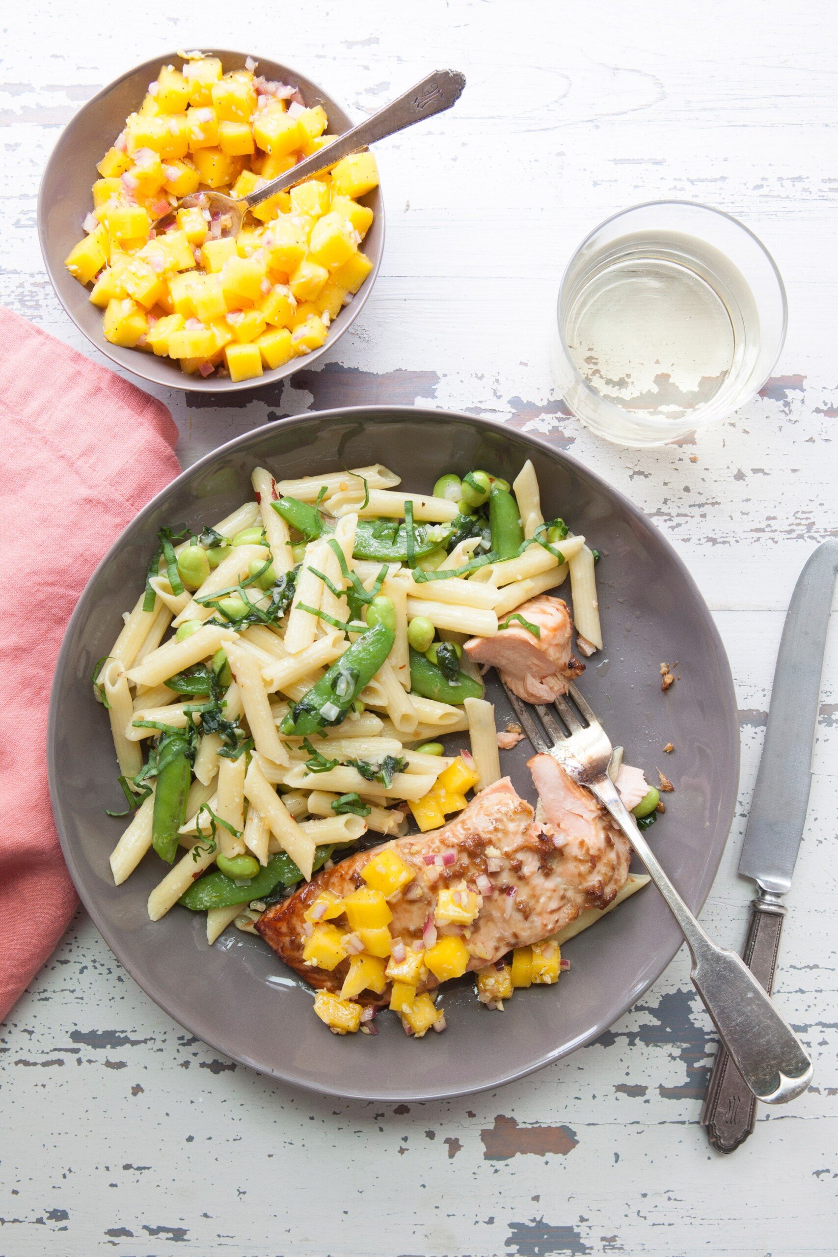 Pasta on a plate with chicken topped with Citrusy Mango Ginger Salsa.