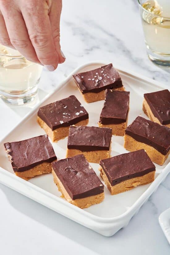 Chocolate Peanut Butter Bars on a white dish set on a marbled table.