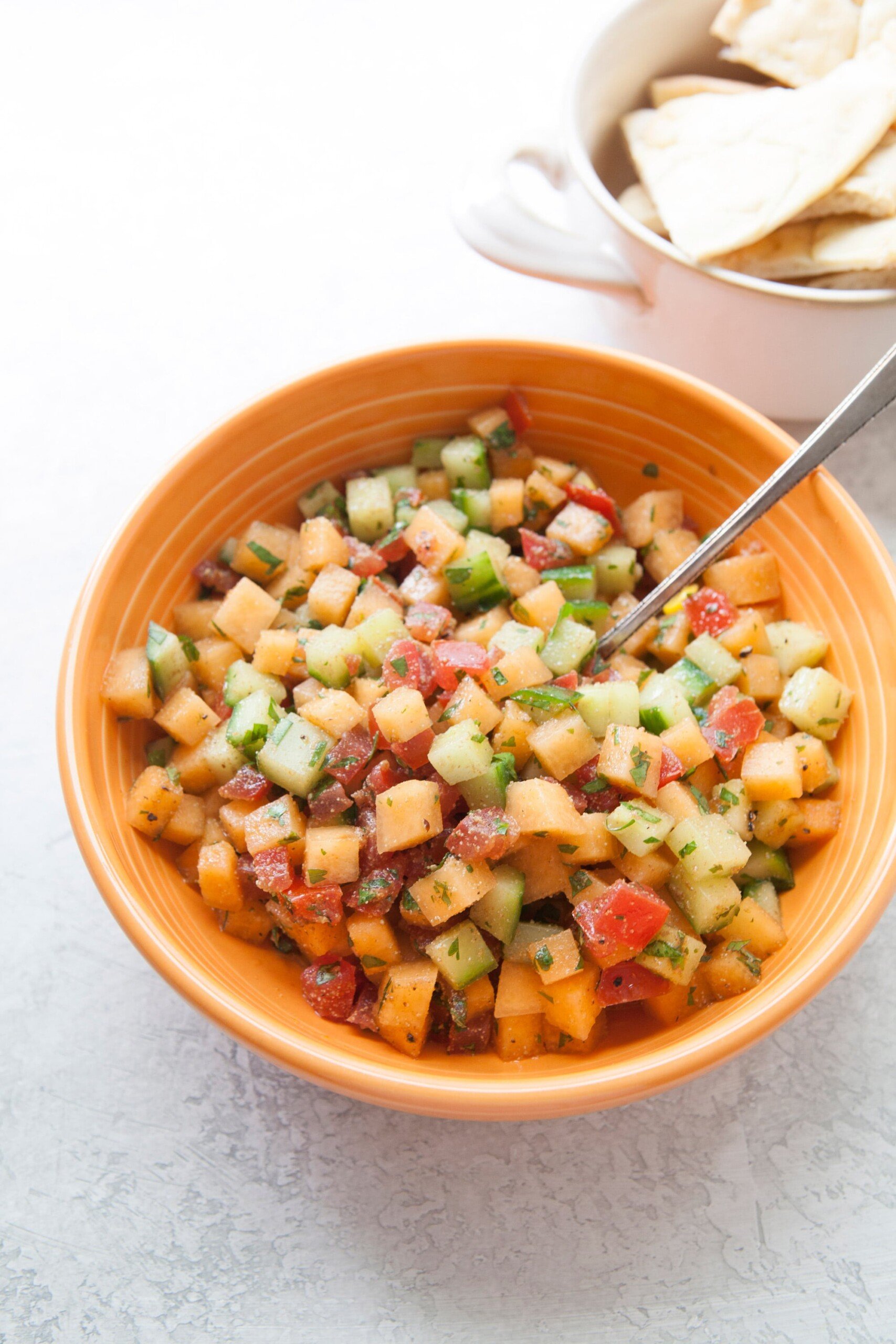 Corn, Cucumber and Cantaloupe Salsa in an orange bowl.