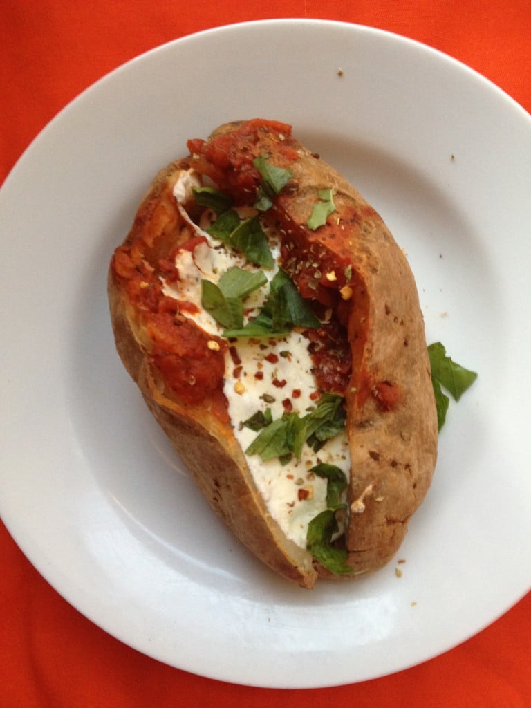 Baked potato topped with sauce, cheese, and pizza seasonings.