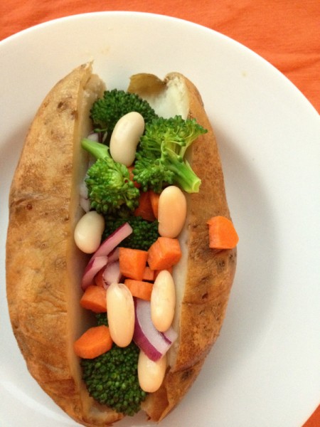 Baked potato topped with vegetables and beans.