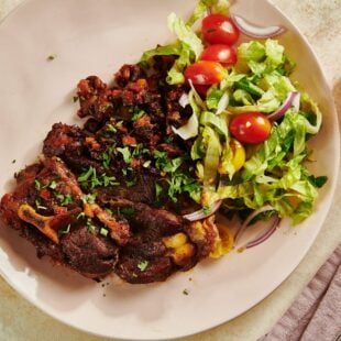 Salad and Braised Lamb Shoulder Chops on a white plate.