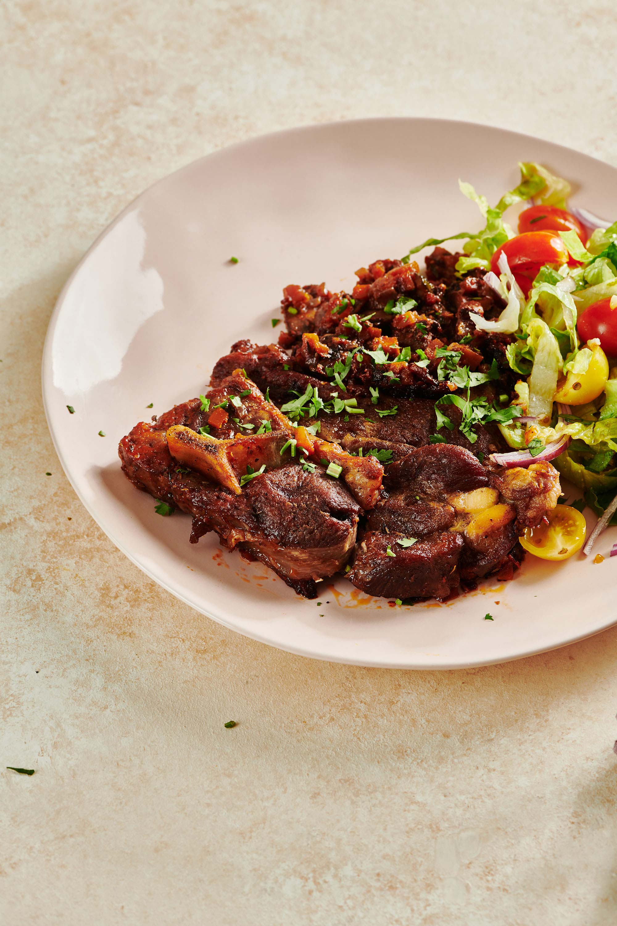 Plate of Braised Lamb Shoulder Chops and salad.