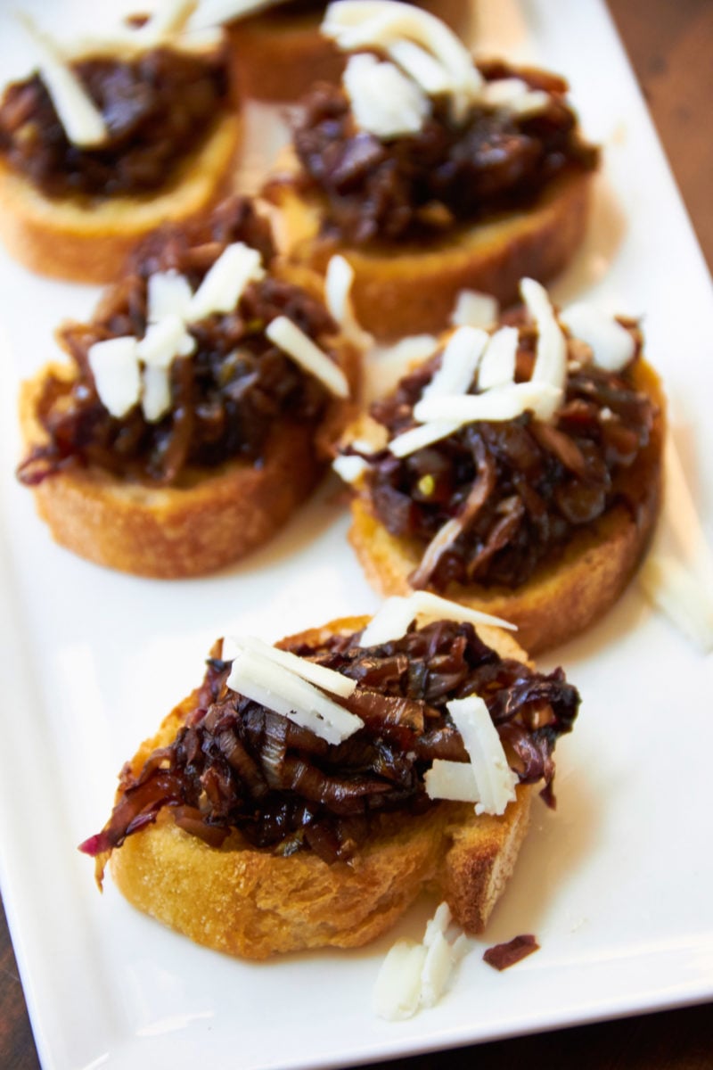 Radicchio and Endive Crostini with Aged Goat Cheese and Balsamic Glaze on a white plate.