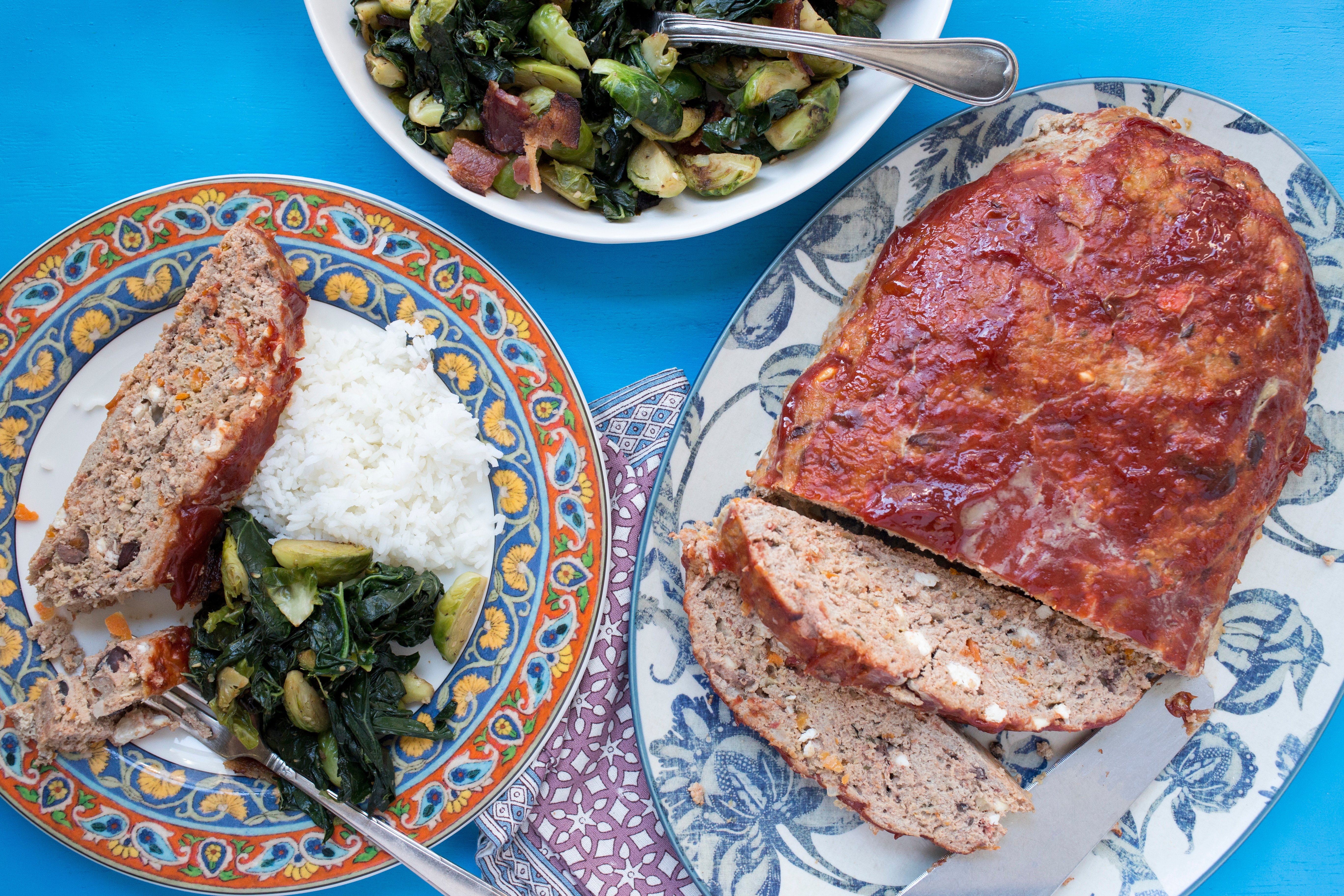 Greek Meatloaf on serving platter with side dishes.