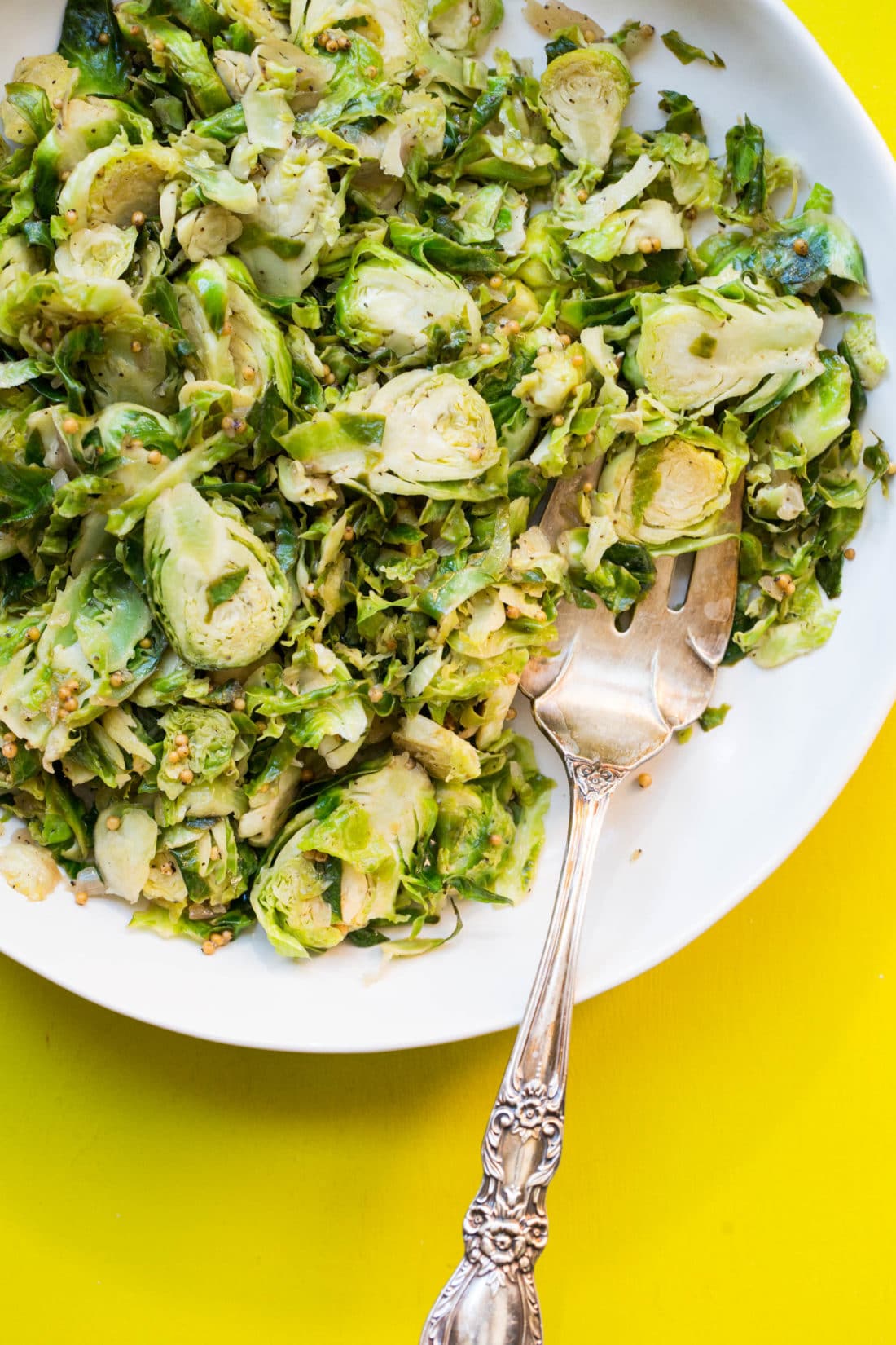 Fork and Shredded Brussel Sprouts on a white plate.