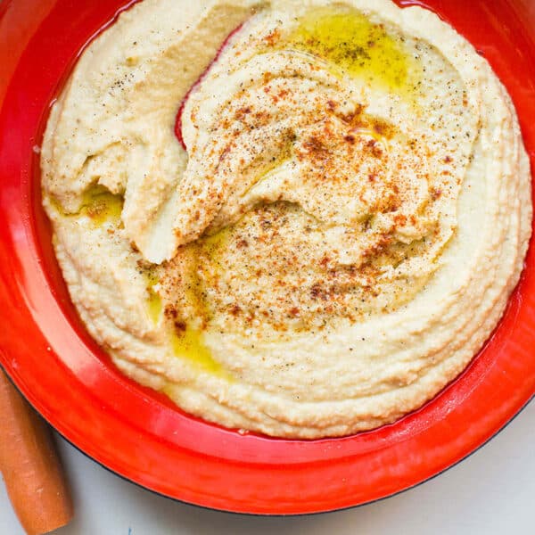 Red bowl of sesame oil hummus.