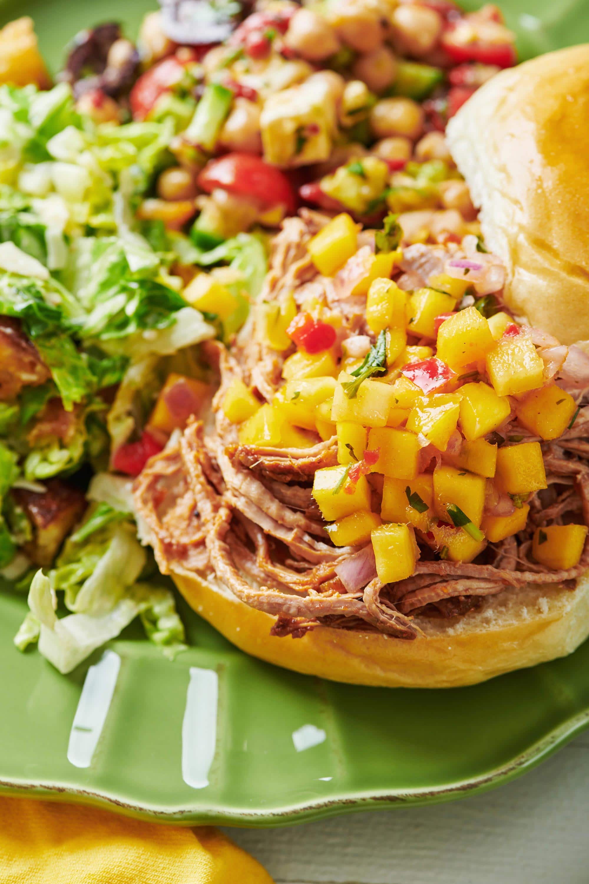 Slow Cooker Barbecue Pulled Pork on a bun with tropical fruit salsa.