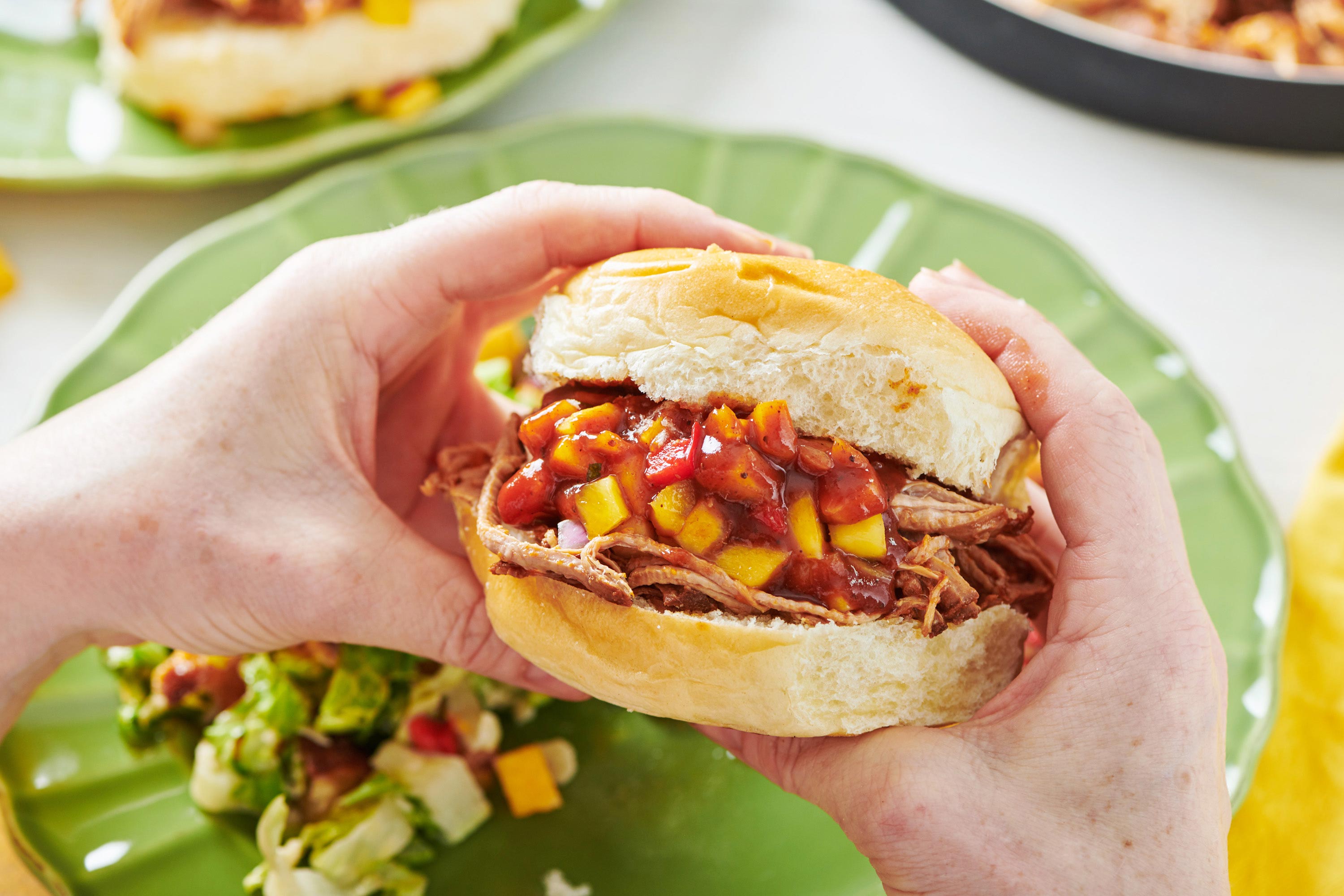 Woman holding Slow Cooker Barbecue Pulled Pork sandwich.