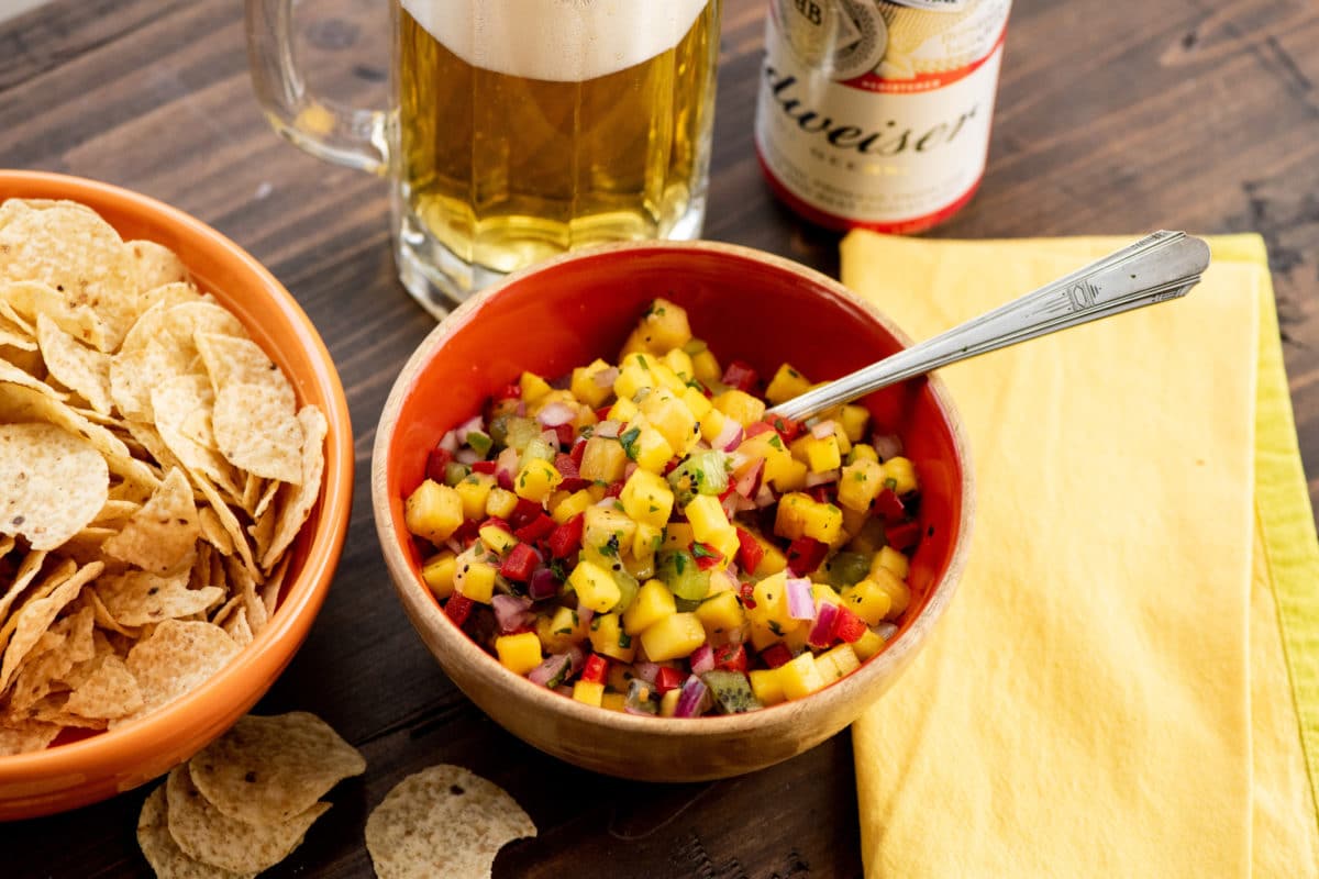 Bowl of Tropical Fruit Salsa on a table with a Budweiser.