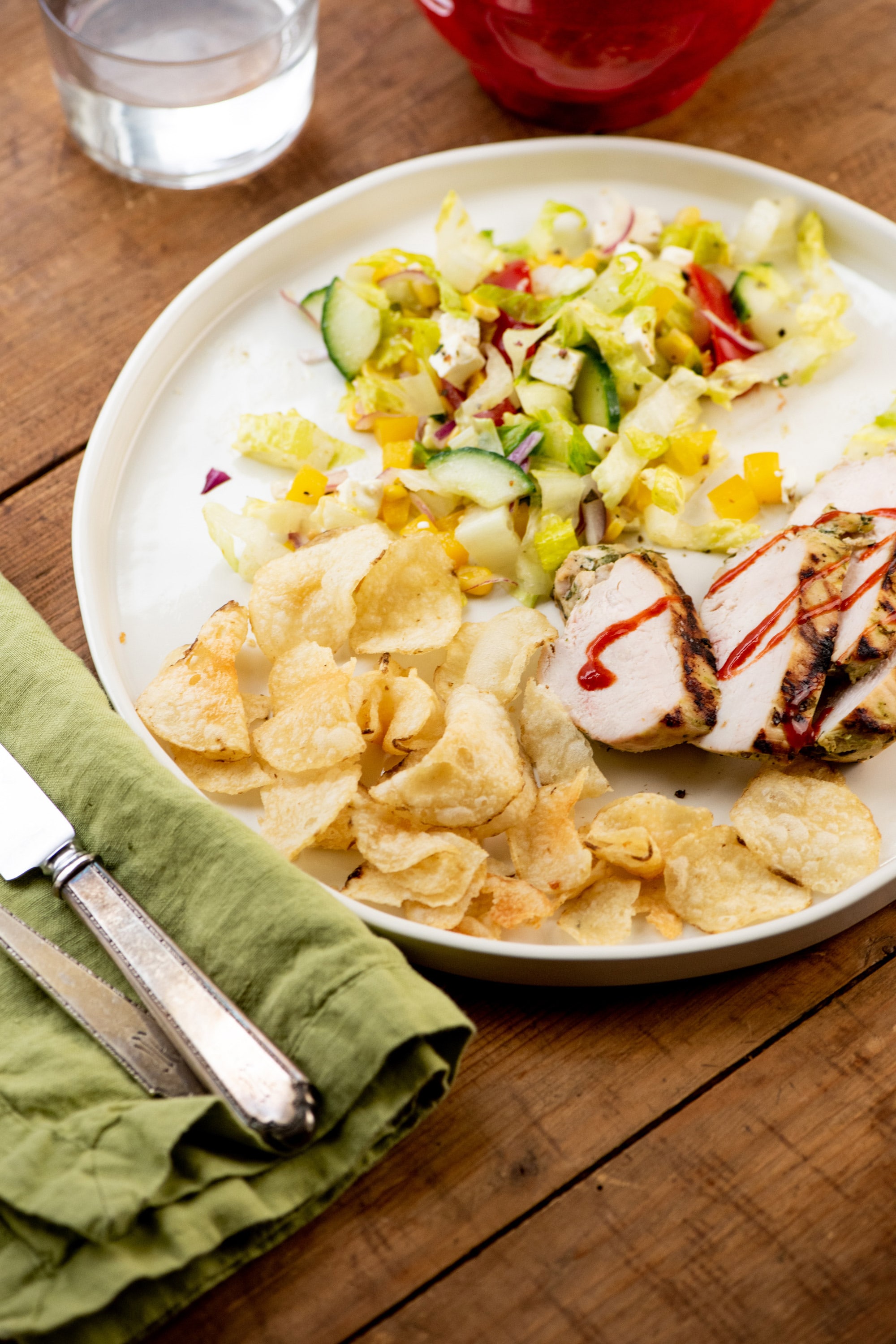 Plate with chips, salad, and Grilled Chicken Breasts with Lime, Roasted Garlic and Fresh Herb Marinade.