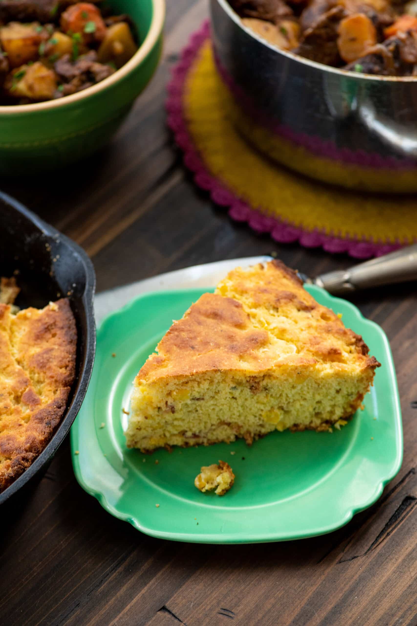 Slice of Bacon, Fresh Corn, and Oregano Cornbread on a small plate.