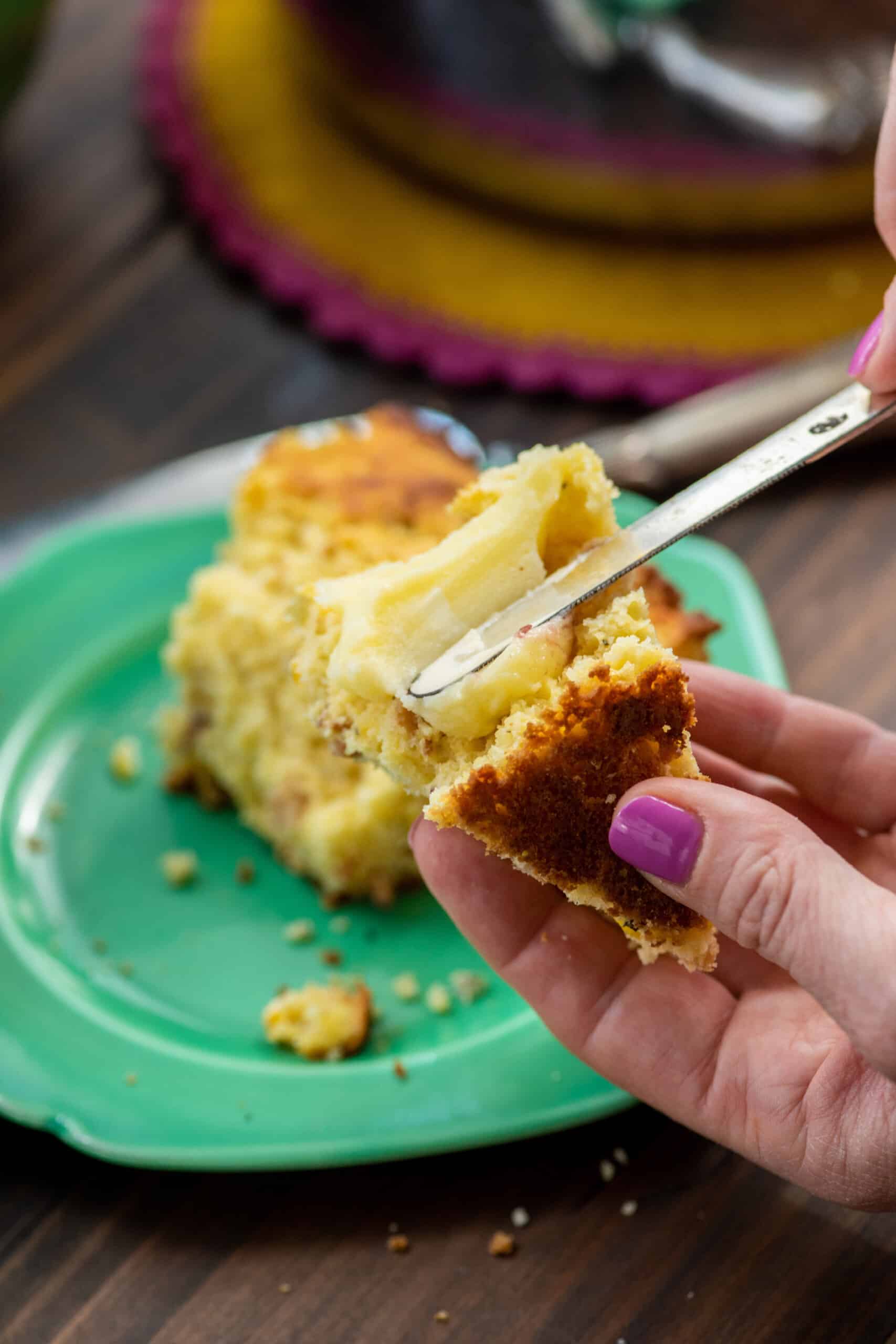 Woman spreading butter onto Bacon, Fresh Corn and Oregano Cornbread.