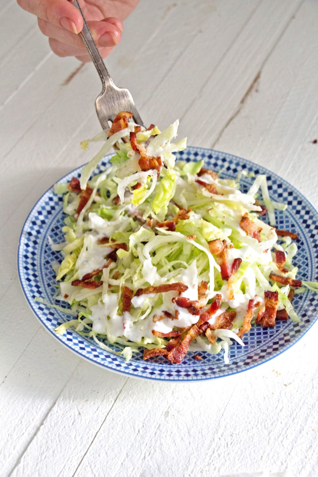 Fork grabbing some Slivered Wedge Salad with Buttermilk Dressing and Bacon.