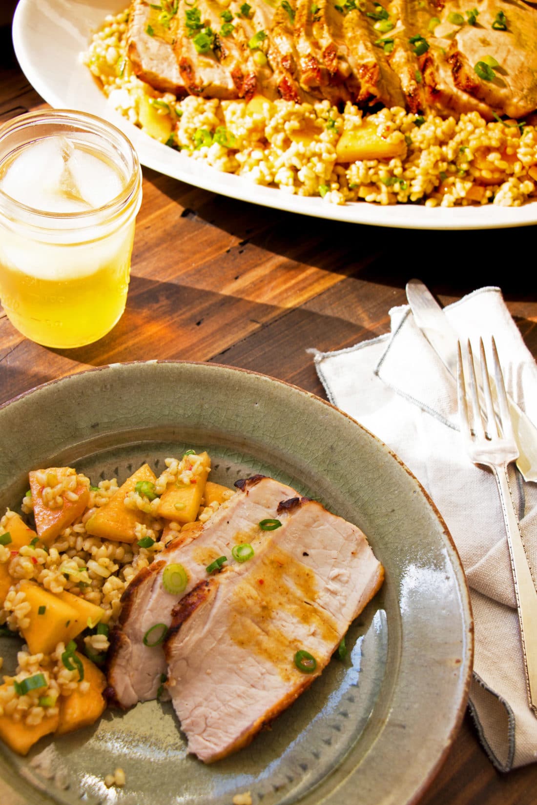 Plate with slices of Grilled Pork Loin and Brown Rice Salad.