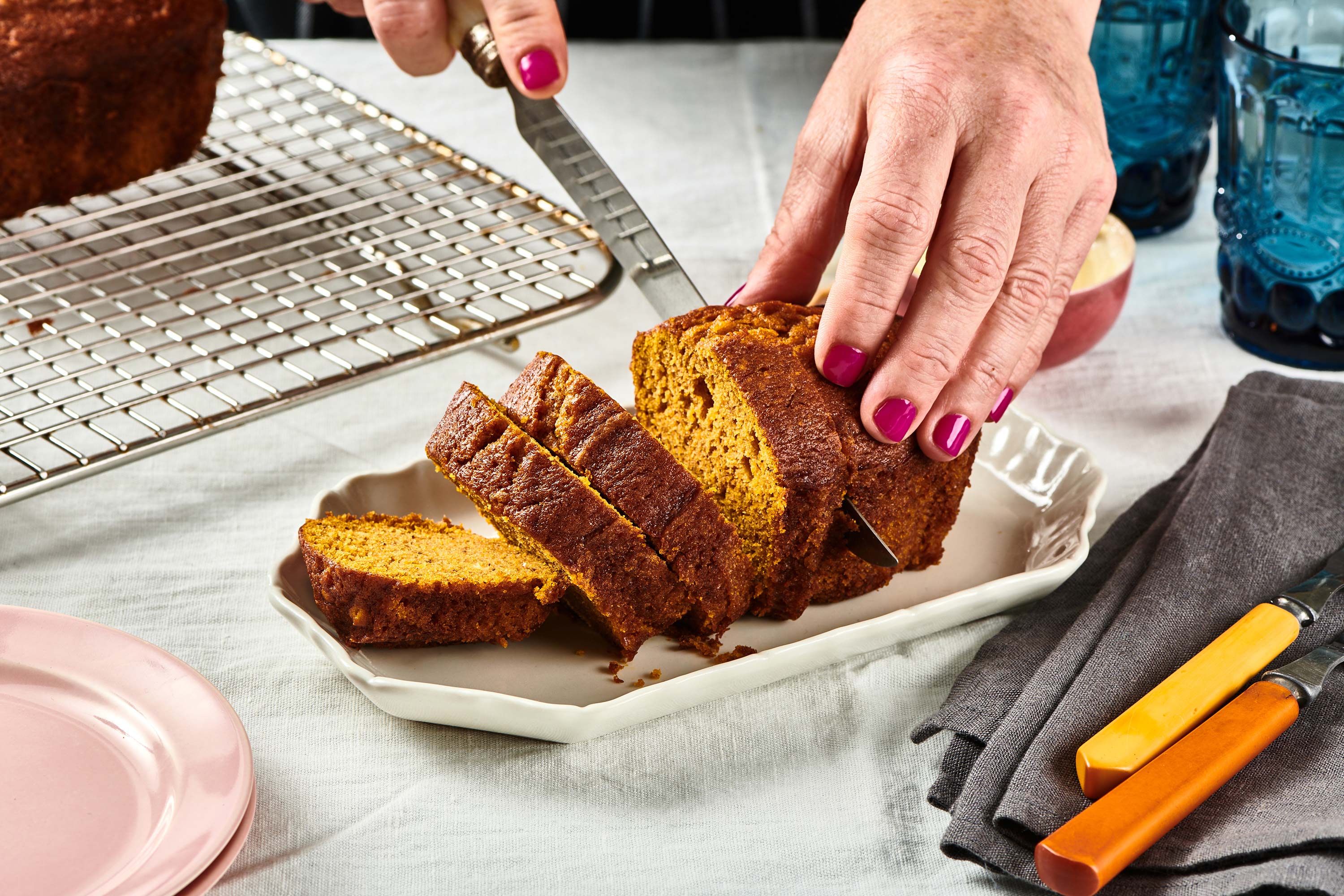 Woman slicing Moist Pumpkin Bread.