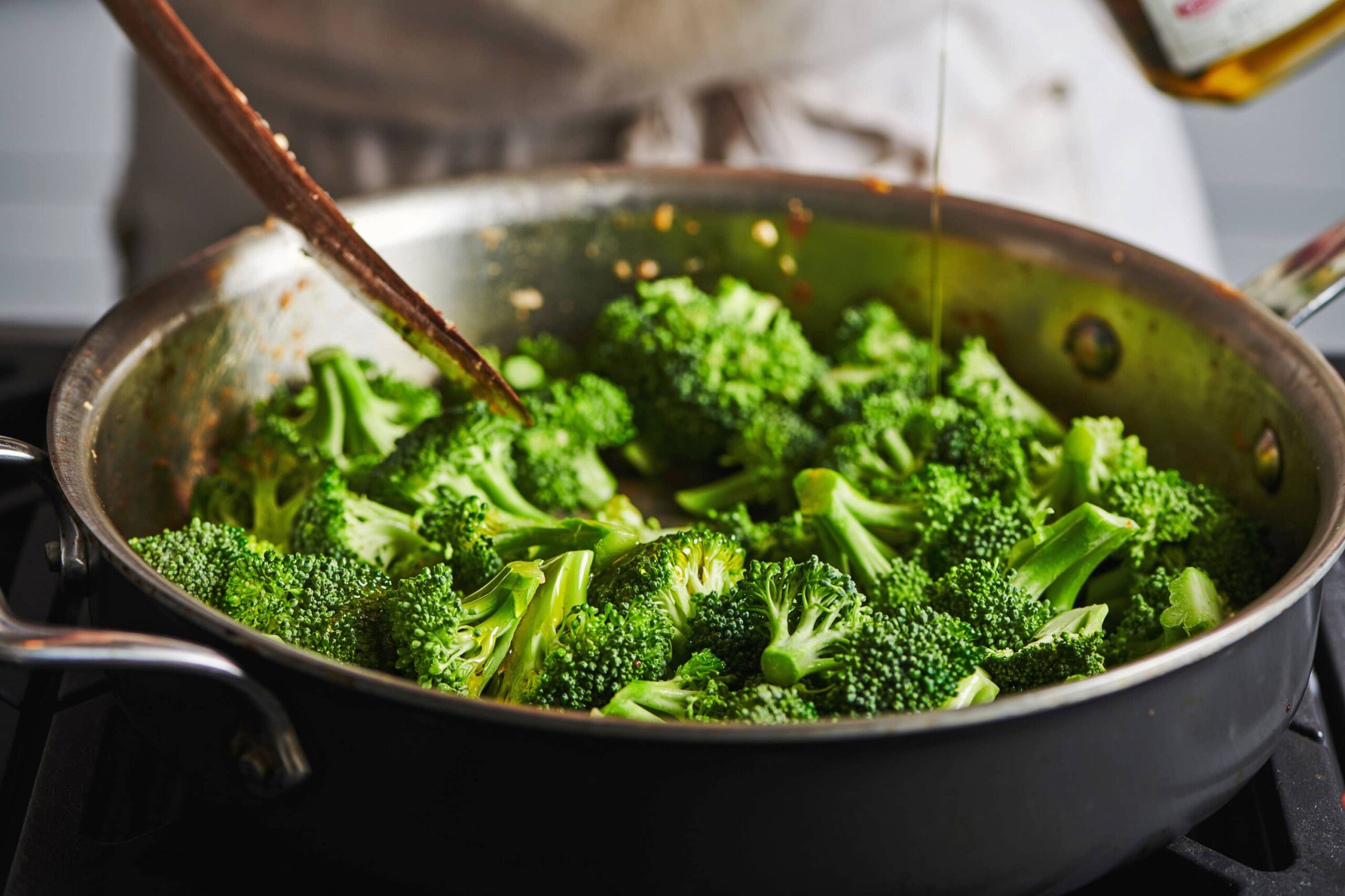 Broccoli cooking in pan on stove.