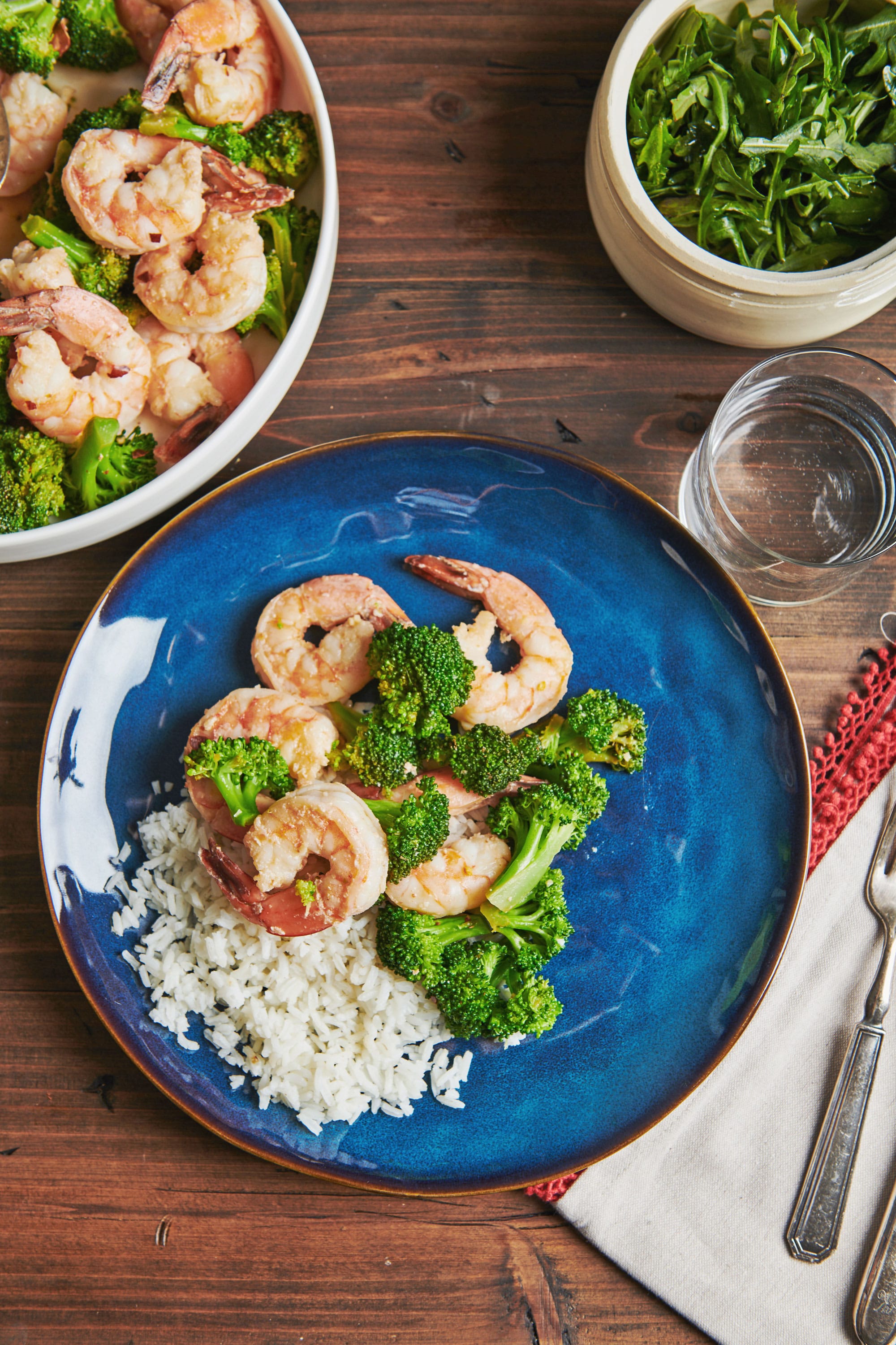 Blue plate of Garlicky Shrimp and Broccoli with Meyer Lemon over rice.