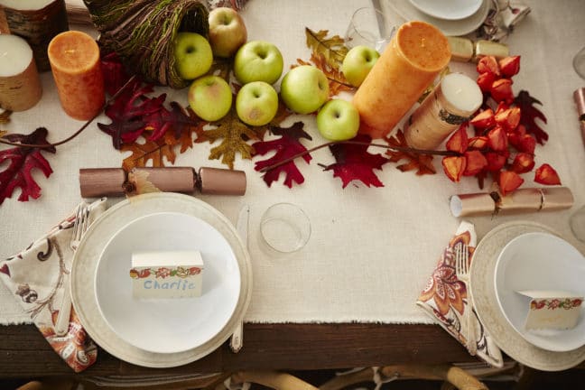 Namecard that reads \"Charlie\" on a plate set on a fall-decorated table.