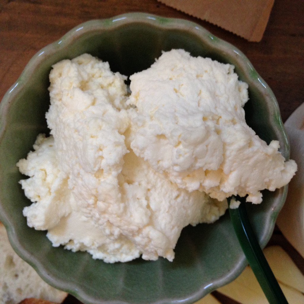 Spoon in a bowl of smoked ricotta.