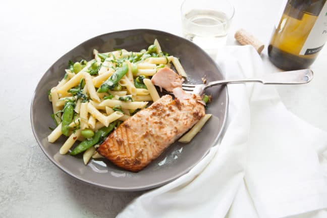 Horseradish Ginger Salmon on gray plate with snap pea and penne side dish.