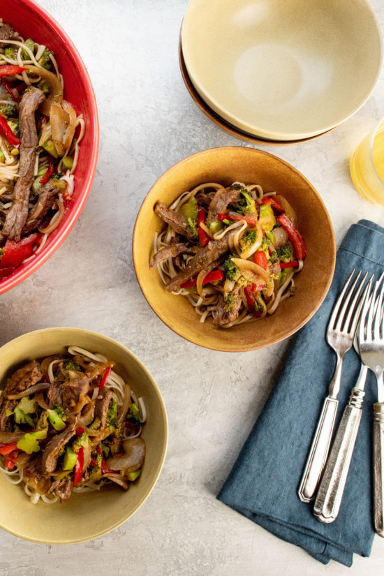 Two bowls of Spicy Stir Fried Beef and Vegetables over noodles.