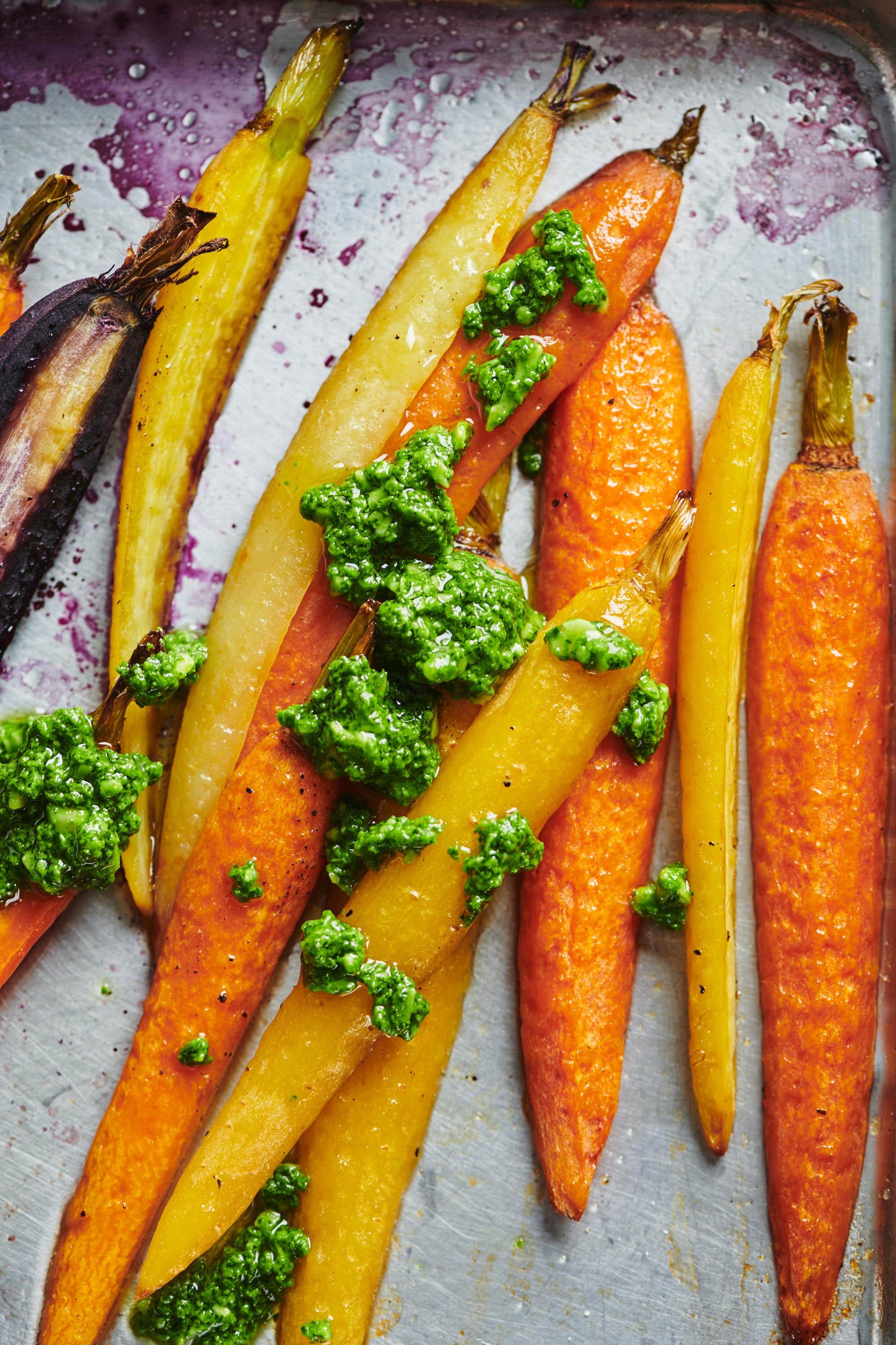 Roasted Carrots with Spinach Parsley Pesto on a baking sheet.