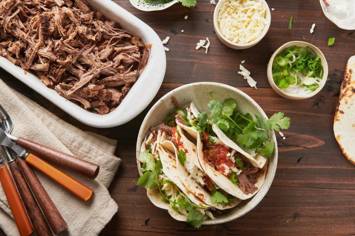 Barbacoa beef in a dish and in tacos.