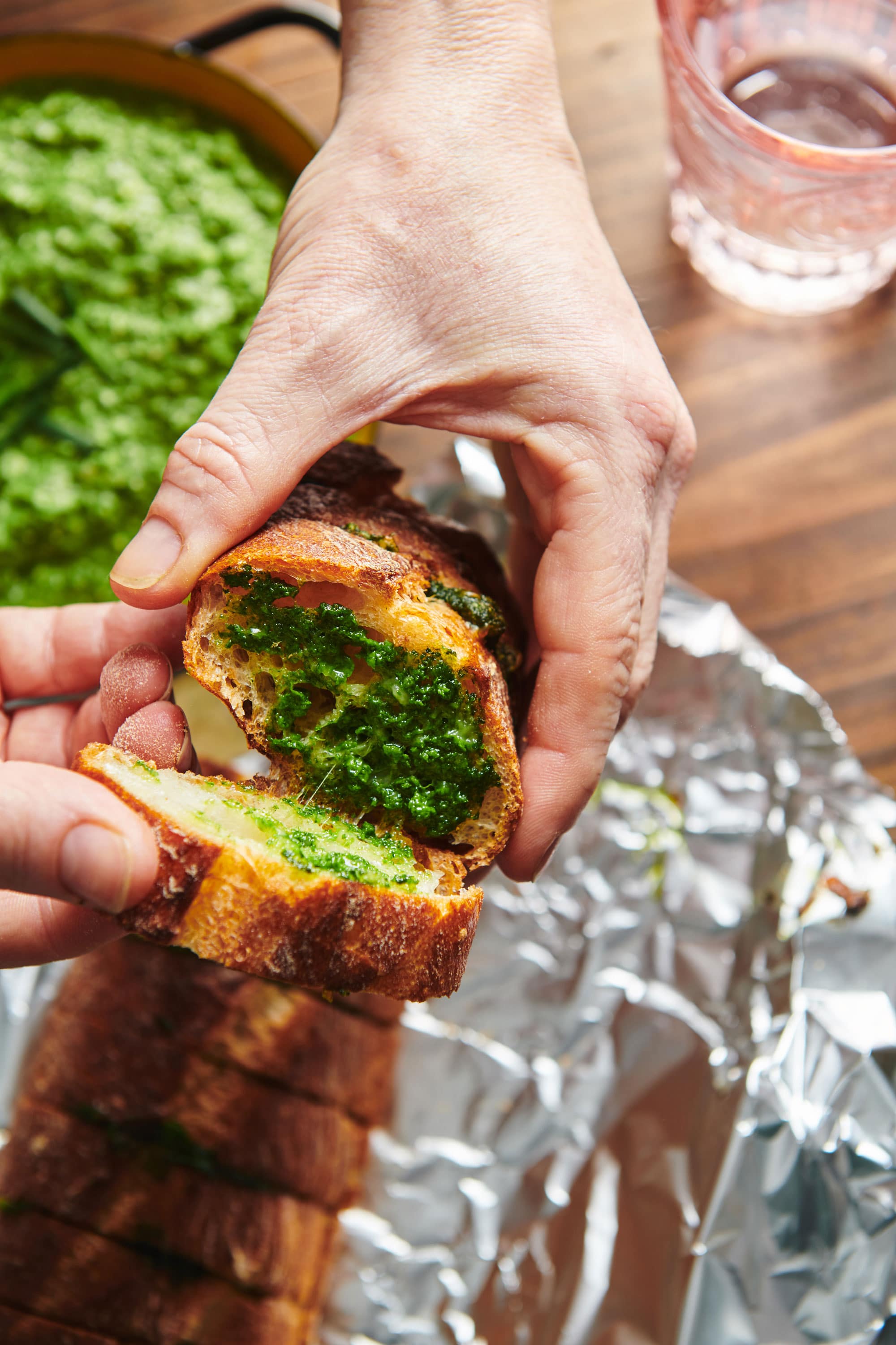 Pulling apart slices of Spinach Parsley Pesto Garlic Bread.