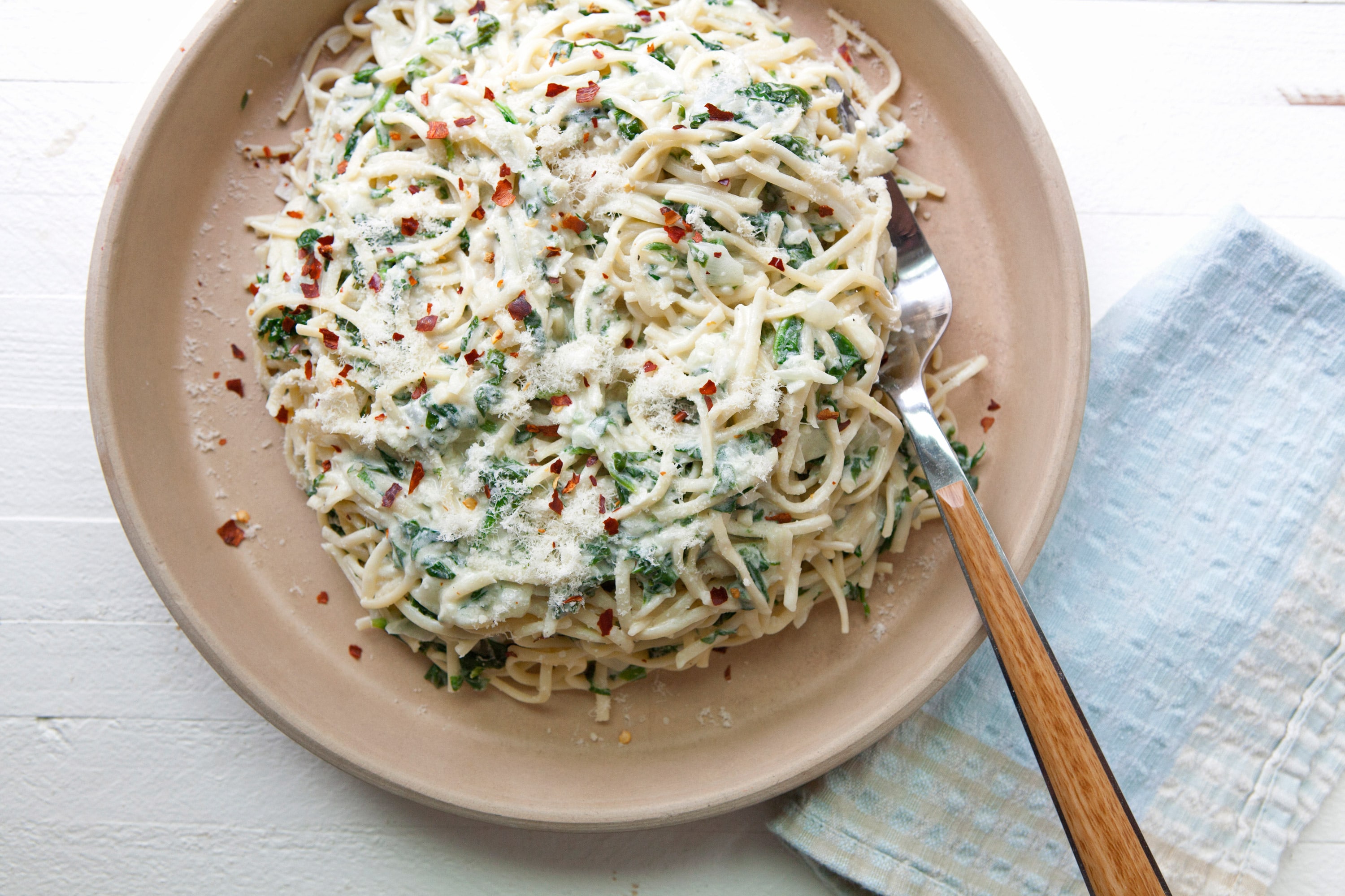 Creamy goat cheese and spinach linguine in bowl