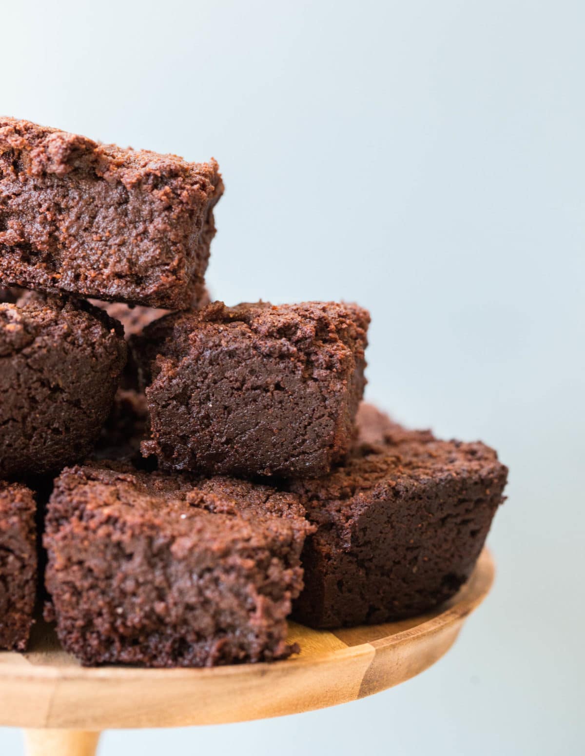 Wooden serving platter with a pile of Mexican Hot Chocolate Brownies.